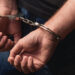 Close up of male hands in bracelets behind back
