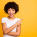 Portrait of her she nice cute lovely charming attractive cheerful cheery glad optimistic wavy-haired girl pointing aside copy space isolated on bright vivid shine yellow background.