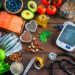 Healthy food for heart care: overhead view of healthy food rich in Omega-3 and antioxidants and a blood pressure monitor, tape measure and stethoscope shot on wooden table. The composition includes a salmon fillet, sardines, avocado, extra virgin olive oil, brown lentils, celery, artichoke blueberries, celery, carrots, brown lentils, asparagus, artichoke, broccoli, flax seeds, chia seeds and some nuts like almonds, pistachio and pecan. High resolution 42Mp studio digital capture taken with SONY A7rII and Zeiss Batis 40mm F2.0 CF lens