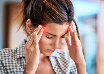 Shot of a uncomfortable looking woman holding her head in discomfort due to pain at home during the day