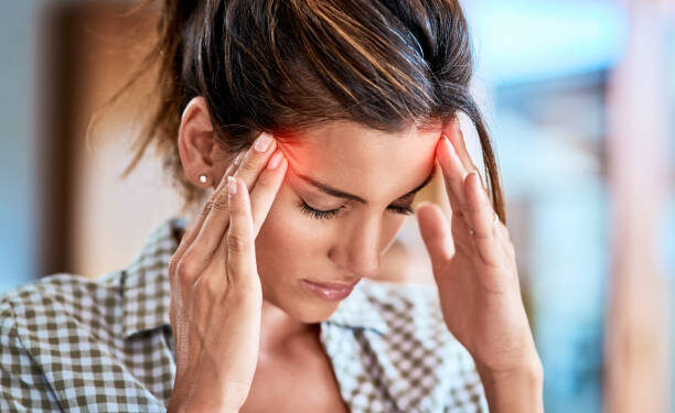 Shot of a uncomfortable looking woman holding her head in discomfort due to pain at home during the day