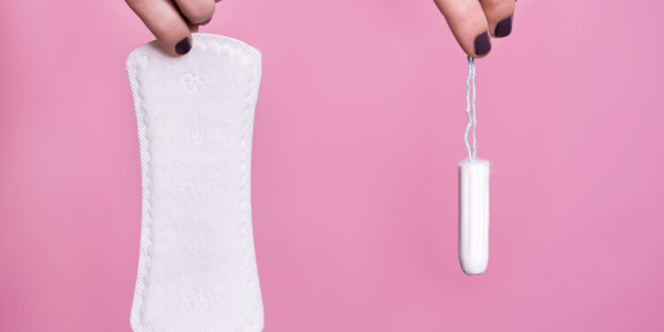 Women holding a sanitary napkin and tampon
